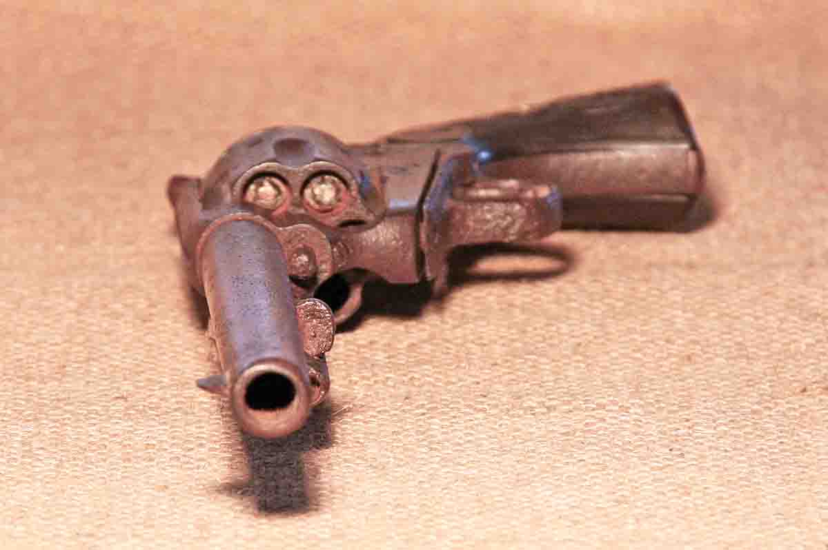 The business end of the Colt, which is completely frozen up from rust. The three loaded cartridges are visible here with white lead oxide on the bullets.